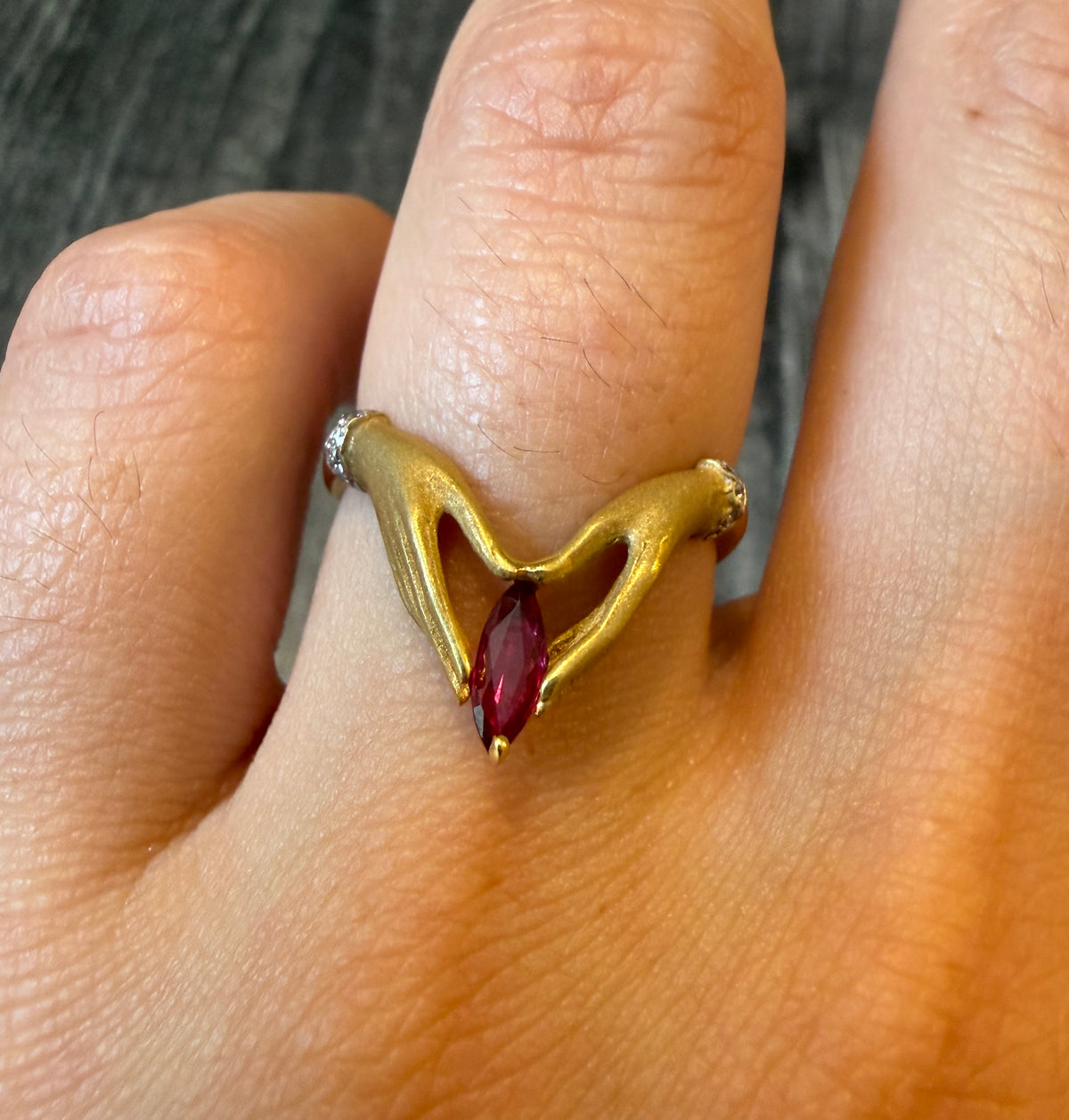 Figural Ring of Two Hands Holding a Ruby in 18K Gold (I)