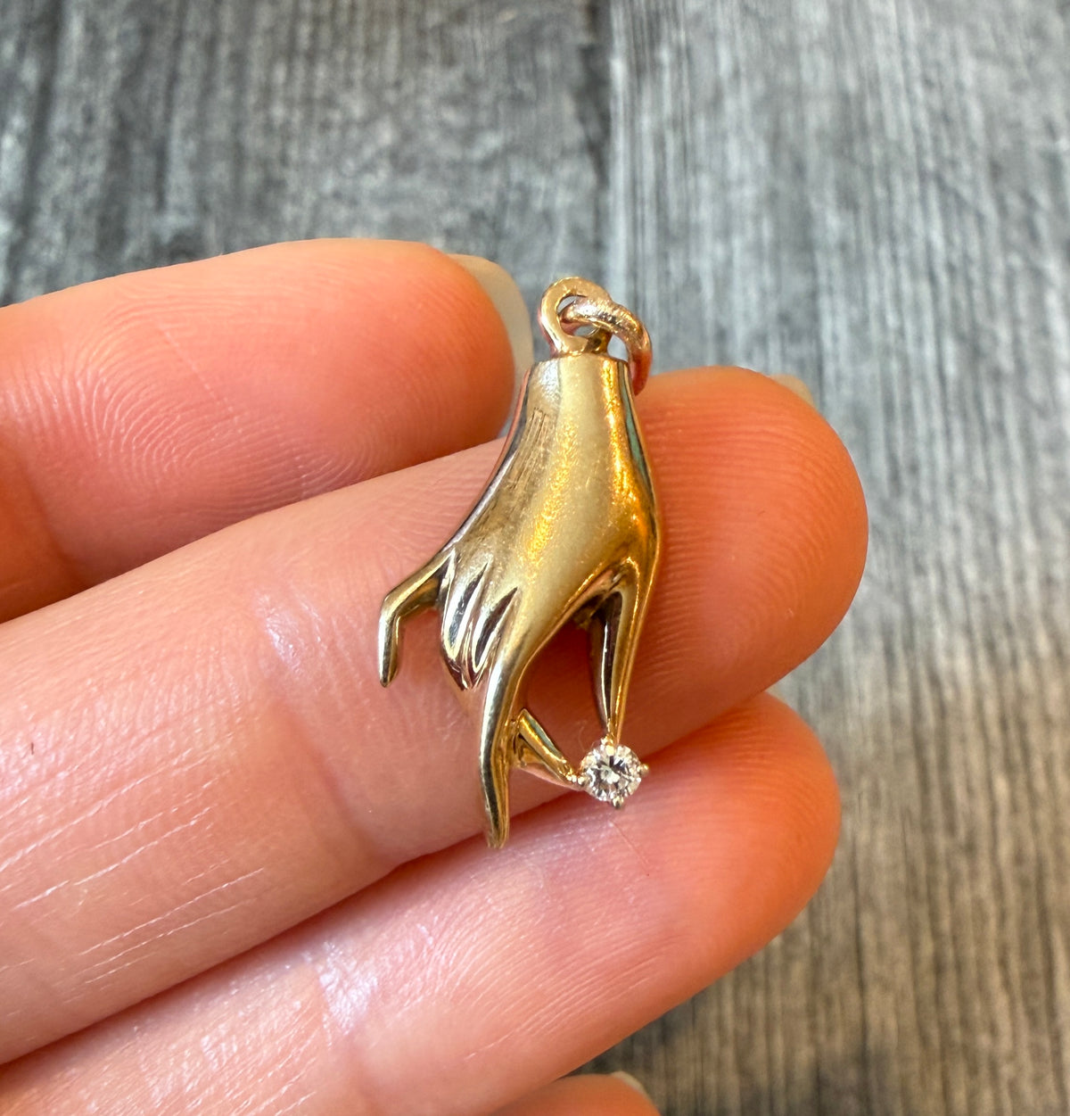 Hand Holding a Diamond Charm in 10K Gold